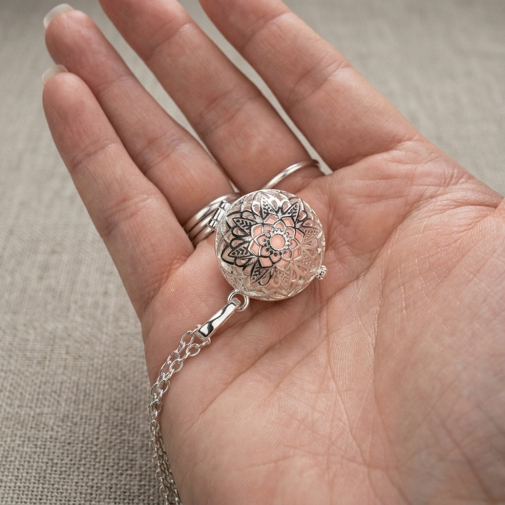 Bola de grossesse rosace à bille rose tenu dans la main